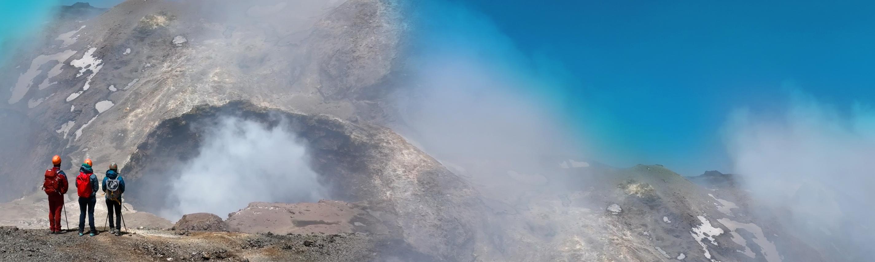 3 Bergsteiger blicken auf eine Bergkulisse, Wolken