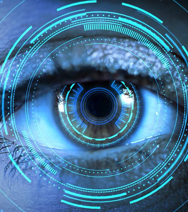 Das Bild zeigt eine extreme Nahaufnahme eines menschlichen Auges. Das Auge ist klar und detailliert zu erkennen, mit einer bemerkenswerten Iris und gut sichtbaren Wimpern. Um das Auge herum sind digitale, abstrakte Grafiken in Blau- und Grüntönen dargestellt, die kreisförmige Muster und Linien bilden, was den Eindruck von Technologie und digitalen Daten vermittelt. Der Hintergrund ist in einem dunklen Farbton gehalten, wodurch das Auge und die grafischen Elemente hervorstechen. Es vermittelt eine futuristische Atmosphäre und thematisiert den Einfluss von künstlicher Intelligenz.