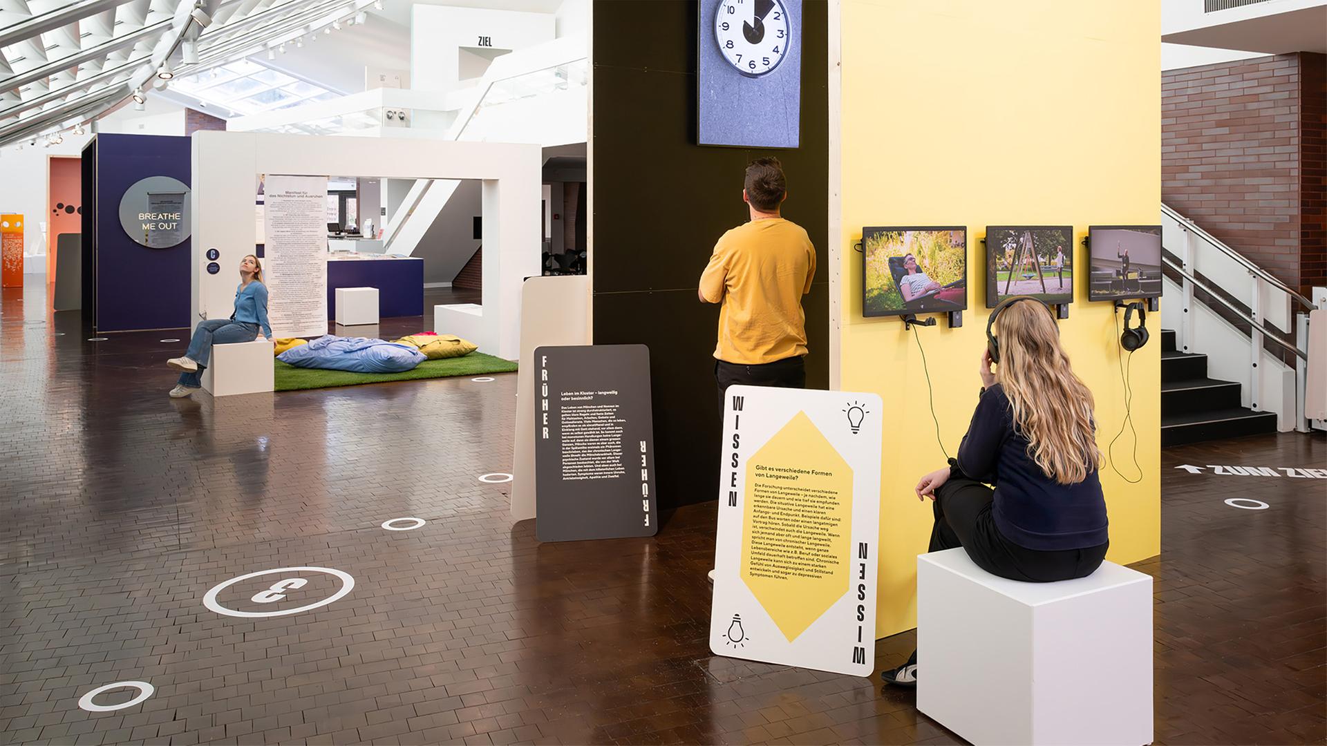 In einem Ausstellungsraum schauen Menschen sich die Exponate an.