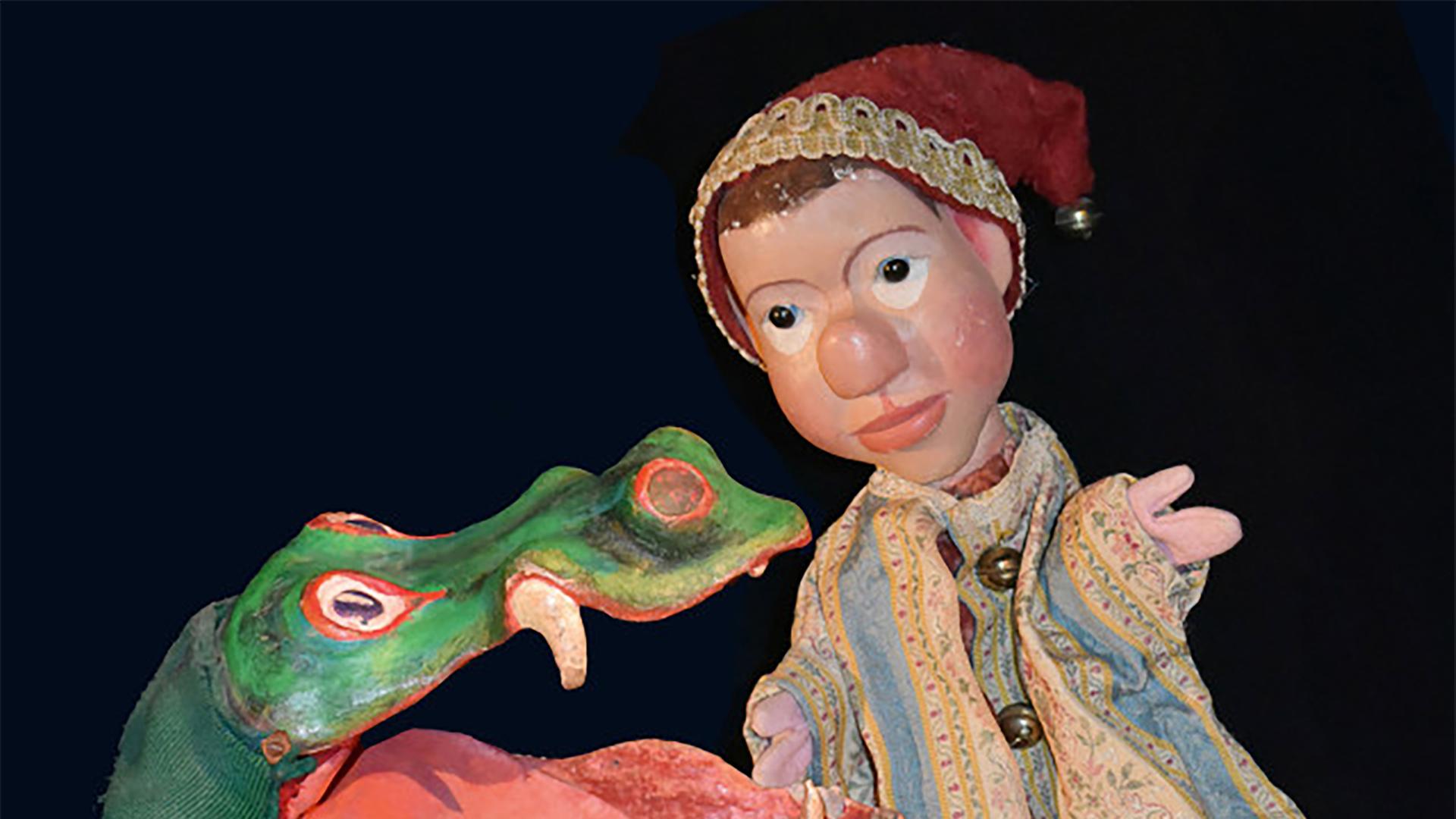 Eine Kasperl-Figur steht links neben einer Krokodils-Handpuppe.