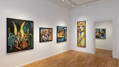 In einem Ausstellungsraum hängen moderne Gemälde an der Wand.