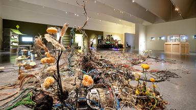 In einem Ausstellungsraum sieht man eine Installation aus Müll.