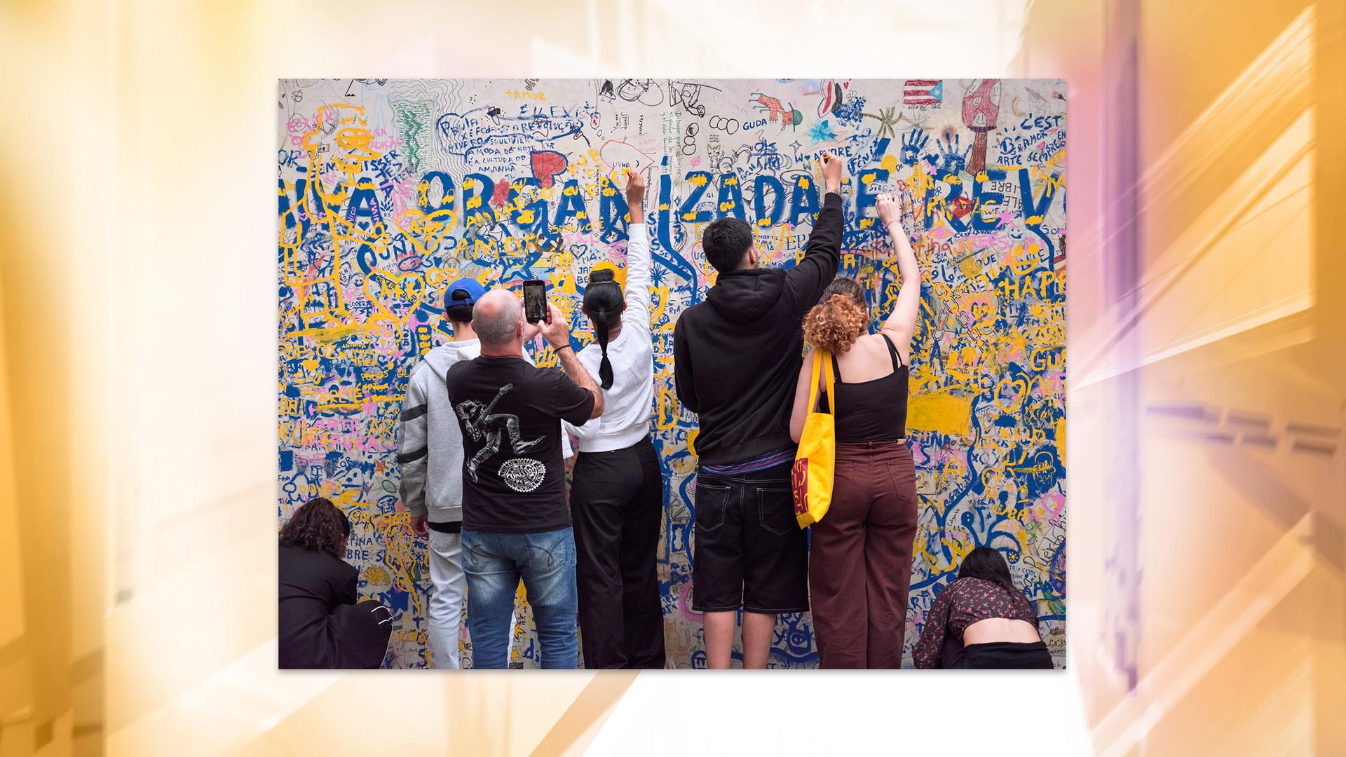 Man sieht wie mehrere Personen an einem Bild malen.