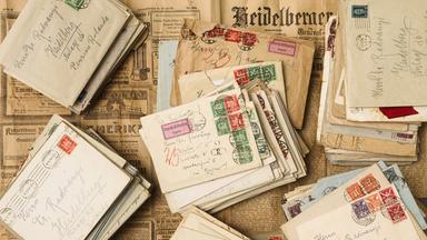 Auf historischen Zeitungen liegen historische Briefe.