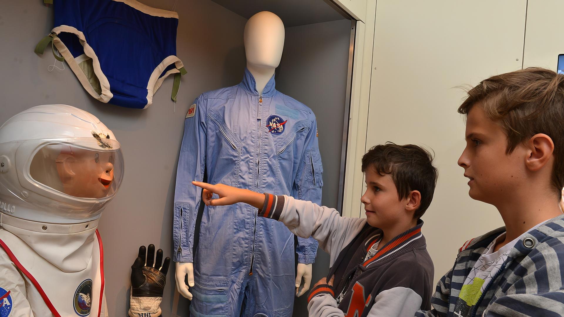 In einem Ausstellungsraum sehen sich zwei Kinder die Raumfahrtsexponate an.