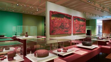 Ausstellungsraum mit hängenden und liegenden roten Lackkunstwerken.