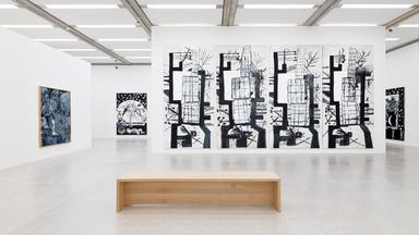 In einem Ausstellungsraum hängen großformatige schwarz-weiße Bilder an den Wänden.