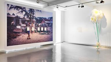 Ein großformatiges Bild mit einer Dorfansicht aus Vietnam hängt in einem Ausstellungsraum