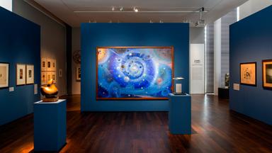 In einem Ausstellungsraum sieht man Bilder und Skulpturen zum Thema Weltraum.