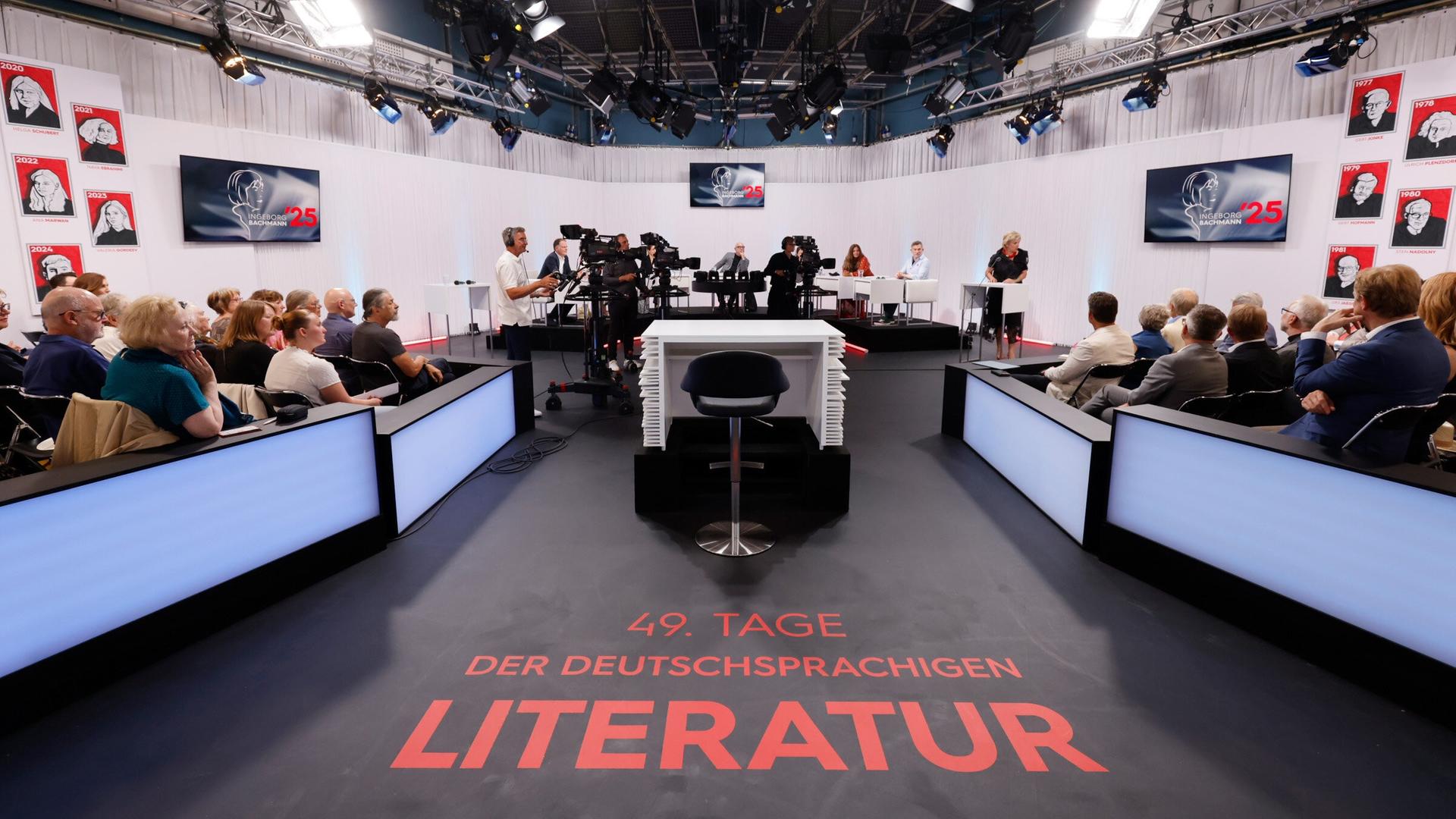 Blick ins ORF-Studio während einer Live-Sendung der Tage der deutschsprachigen Literatur  mit Jurytisch, Publikum, Kamerateam und Schriftzug 49. Tage der deutschsprachigen Literatur auf dem Boden.