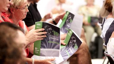 Menschen mit Programmheften in den Händen