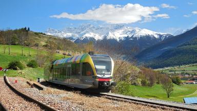 Ein Zug, der durch eine Berglandschaft fährt.