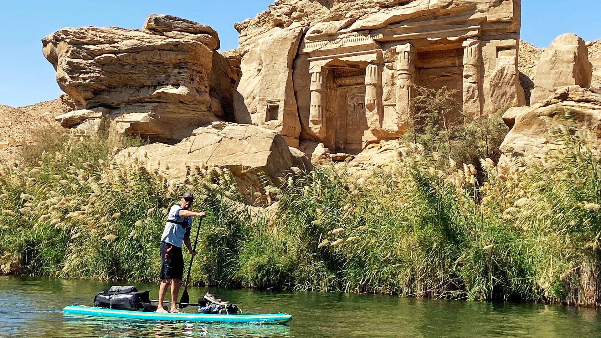 Ein Mann auf einem Paddleboard vor einem Monument.