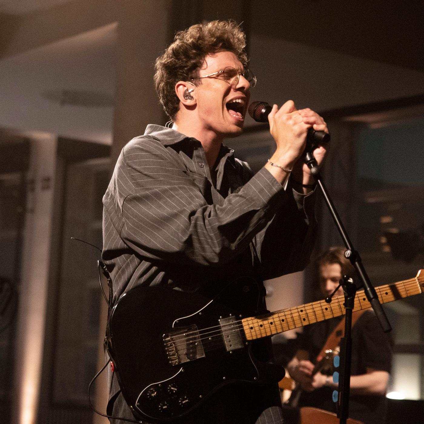 Der Sänger Kamrad singt auf einer Bühne ins Mikro.