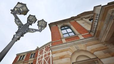 Untersicht auf das Festpielhaus-Gebäude und eine historische Straßenlaterne in Bayreuth.