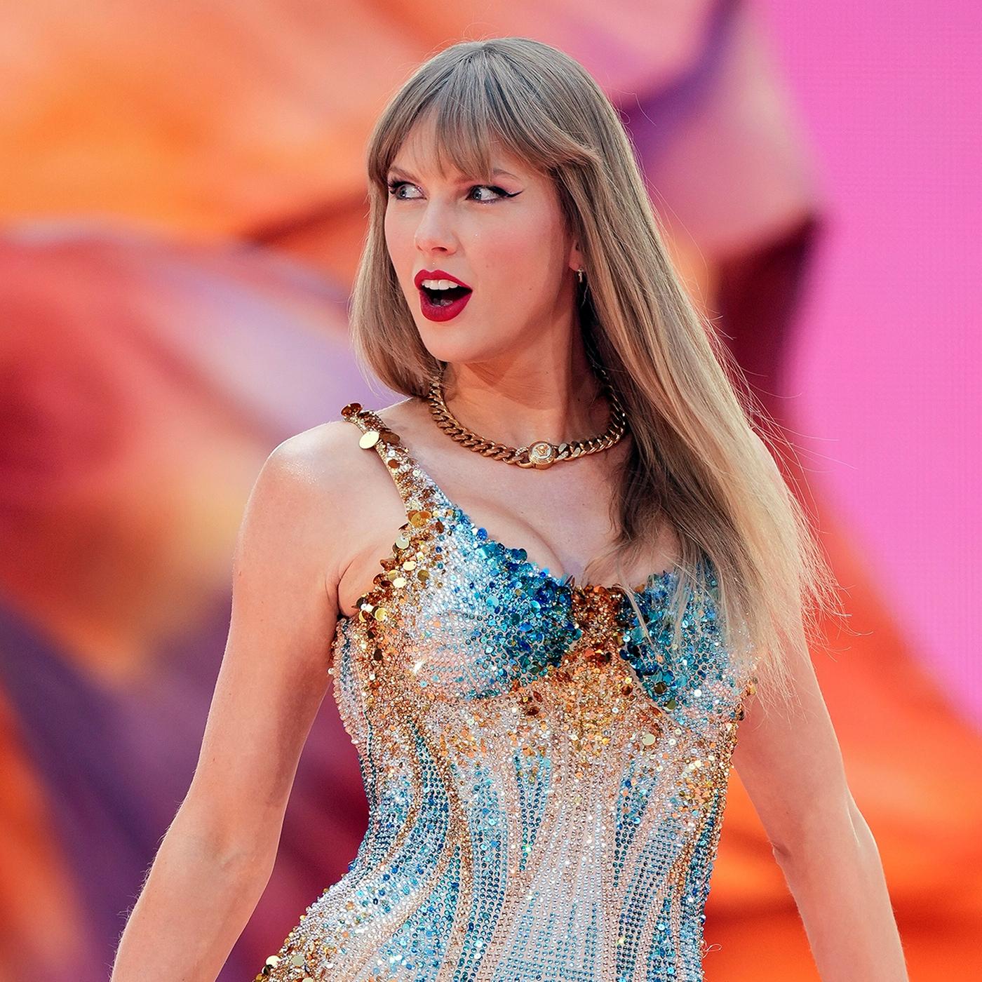 Taylor Swift in einem glitzernden Bühnenoutfit vor farbenfrohem Hintergrund während eines Auftritts ihrer Eras Tour 2024 im Wembley-Stadion in London.