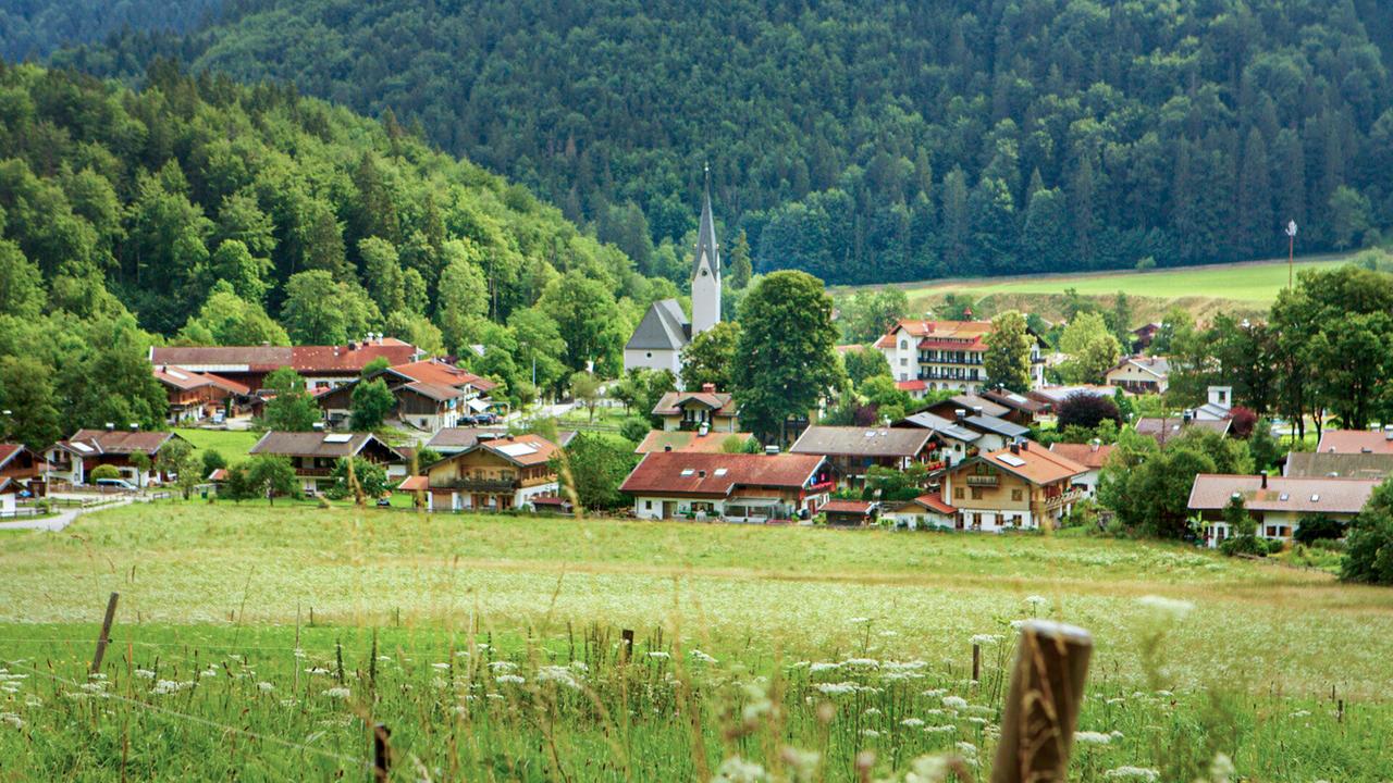 Blick auf ein Bergdorf von einer Wiese aus gesehen