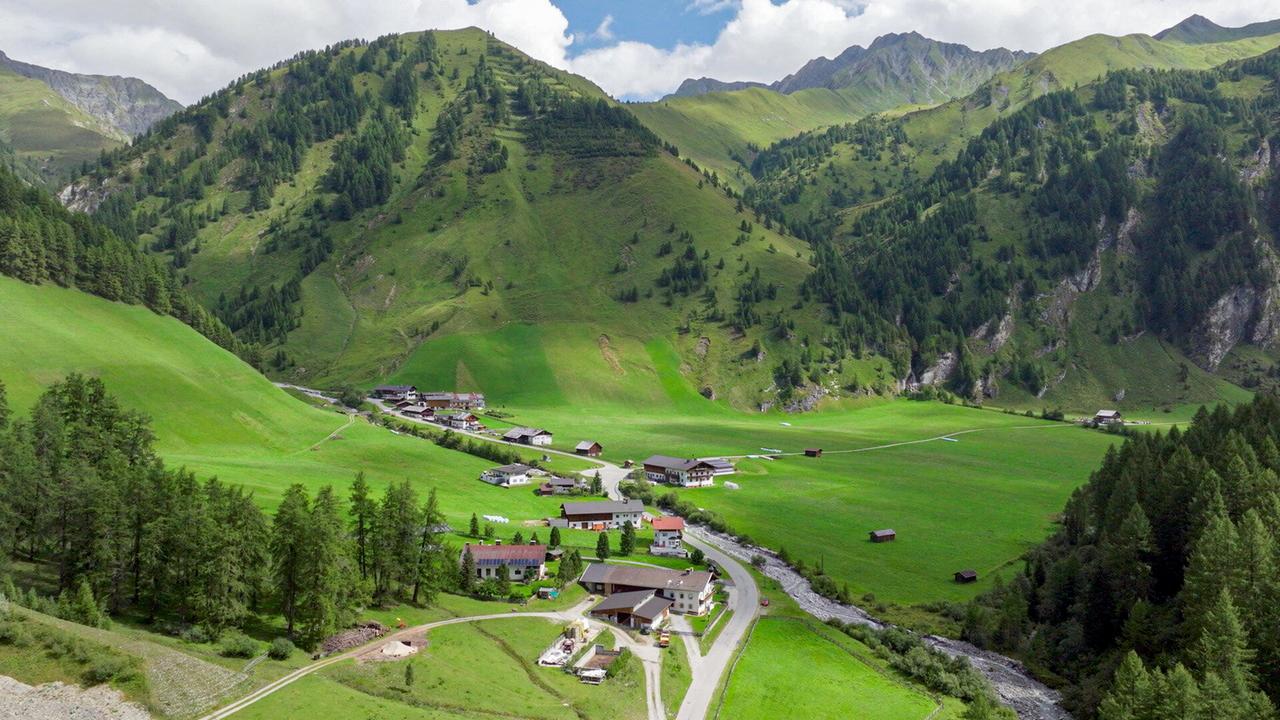 Landstraße, die in ein Dorf führt aus der Vogelperspektive
