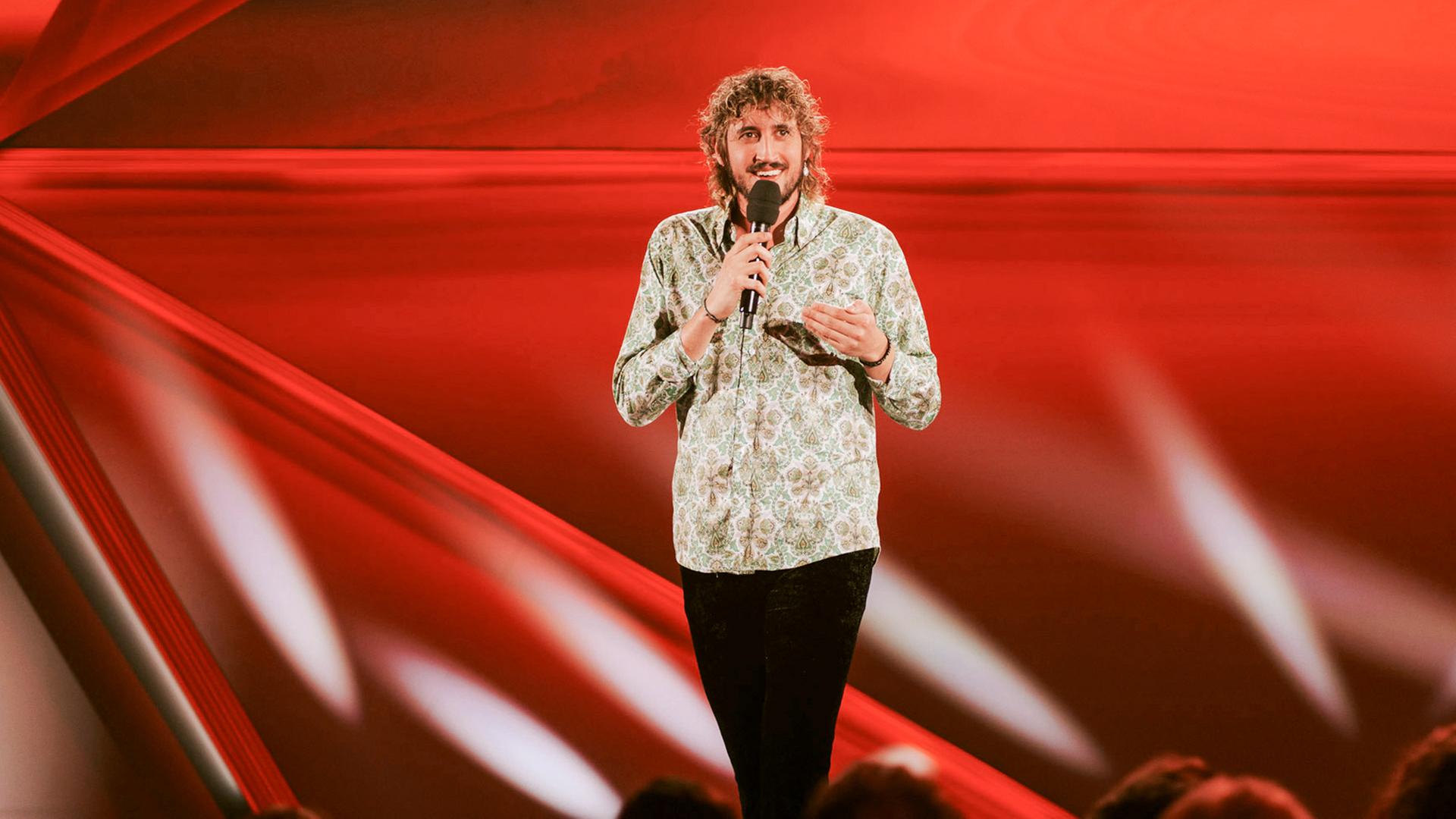 Berni Wagner ist auf der Bühne zu sehen. Er hält ein Mikrofon in der Hand.