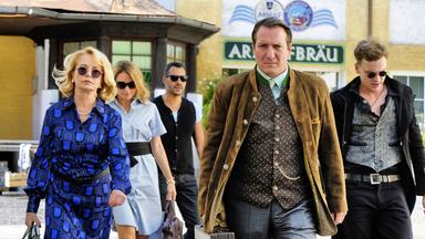 „Bier Royal (1)“: Vor einem gelben Gebäude, auf dem der Schriftzug „Arnulfbräu“ zu erahnen ist, laufen Gisela Hofstetter (Gisela Schneeberger), Vicky Dawson (Lisa Maria Potthoff), Dan Dawson (Michael Klammer), Dr. Erich Maxlhuber (Robert Palfrader) und Patrick Hofstetter (Frank Pätzold).