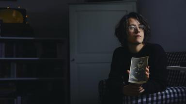 Junge Frau mit alter Fotografie, auf der ein Nazi abgebildet ist.