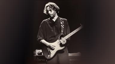 Schwarzweißbild von Eric Clapton auf der Bühne mit einer E-Gitarre.