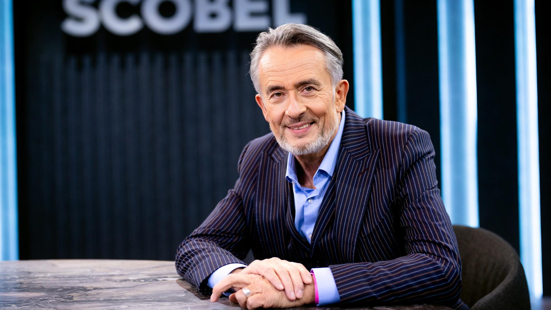 Gert Scobel, sitzend am Tisch, nah