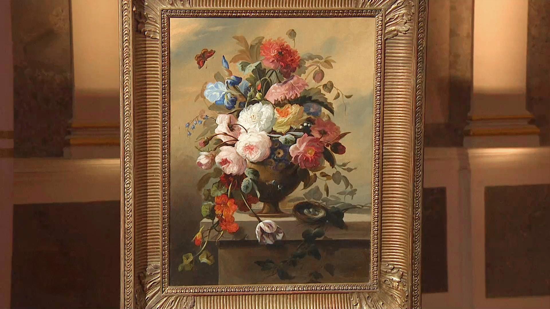 Ein gemaltes Bild von einem Blumenstrauß in einer Vase. Das Bild ist in einem breiten Goldrahmen.