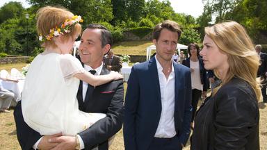 Mann hält Kind auf Arm und wird von Frau misstrauisch angesehen.