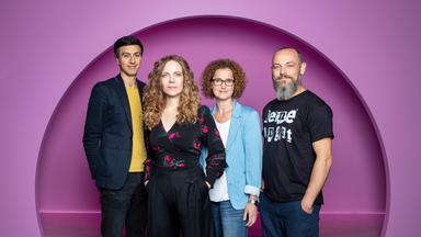 Auf dem Bild stehen vier Personen nebeneinander. Sarah Bosetti ist die zweite Person von Link.  Sie trägt ihr Haar offen und ist schwarz gekleidet. Der Hintergrund ist rosa.