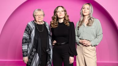 Auf dem Bild ist Sarah Bosetti mittig zu sehen. Links neben ihr steht Luise F Pusch. Auf der rechten Seite des Bildes ist Alicia Joe. Der Hintergrund ist rosa