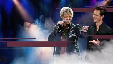 Jo Schück betrachtet ein Bild des Musikers David Bowie