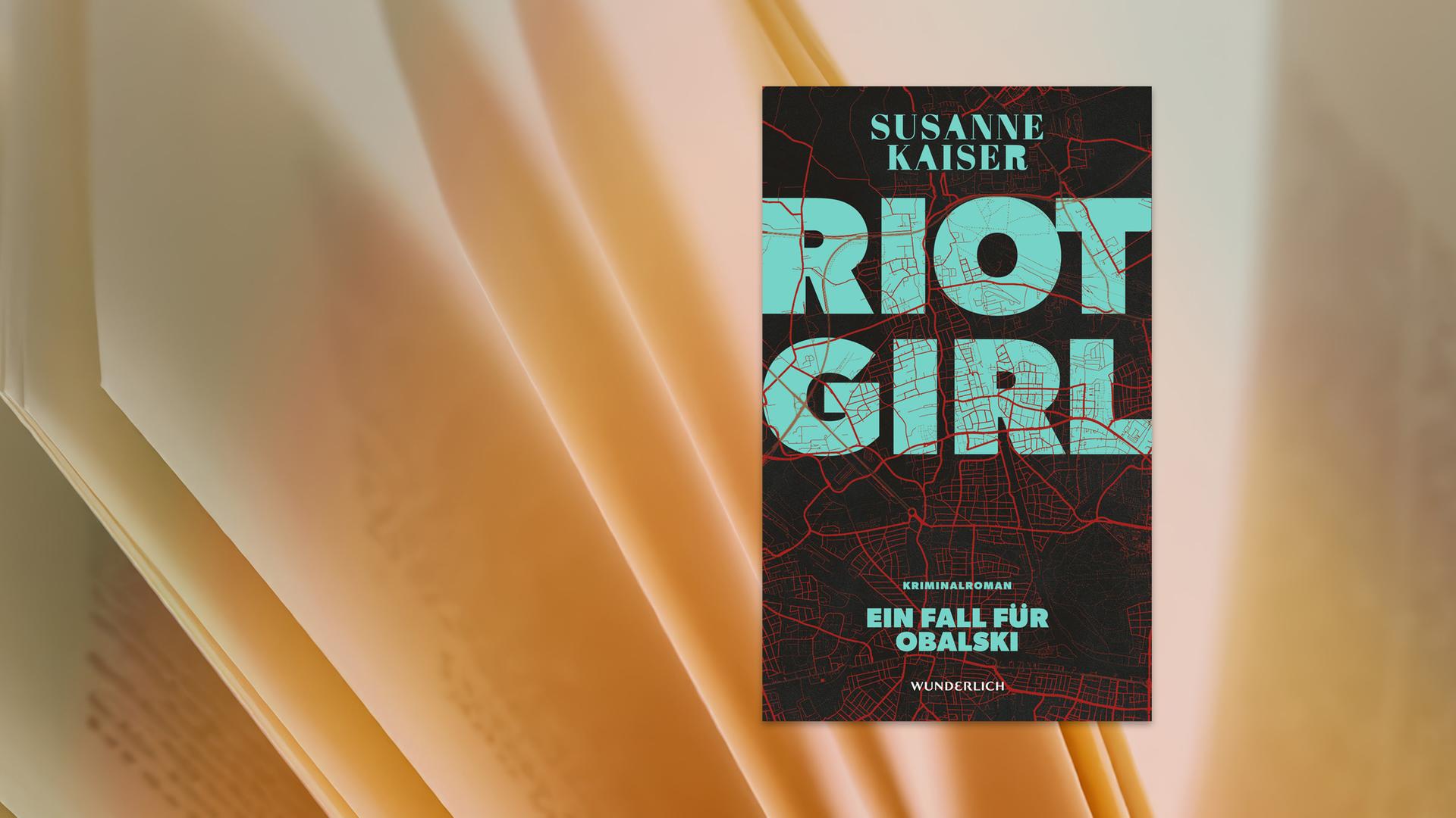 Auf dem Cover des Buches sieht man den Buchtitel in großen türkis-farbenen Buchstaben geschrieben. Den Hintergrund bildet eine schwarz-rot-gehaltene Stadtkarte.