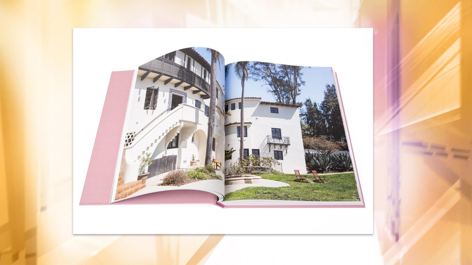 Man sieht aufgeschlagene Buchseiten mit der Fotografie einer Villa mit Garten.