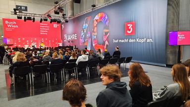 Blick auf eine Bühne mit Zuschauerreihen im Vordergrund