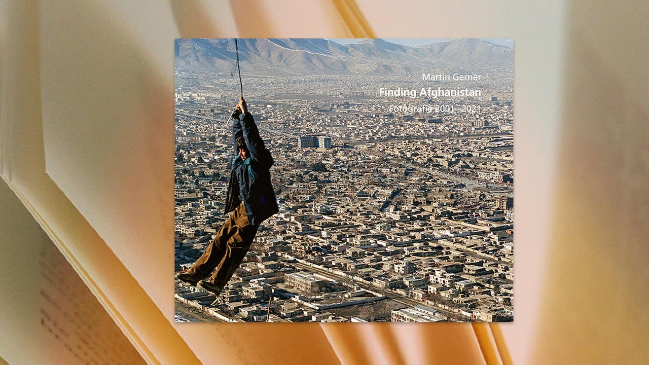 Der Umschlag des Buches "Finding Afghanistan" zeigt einen Mann, der hoch oben an einem Seil hängt. Unter und hinter ihm sind bis zum Horizont die Gebäude einer Stadt zu sehen.