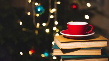 Teetasse auf einem Bücherstapel im Advent
