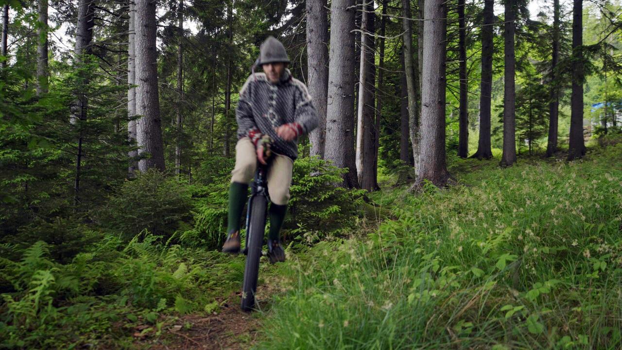 Ein Mann fährt in einem Wald Fahhread