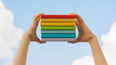 Bücherstapel zwischen zwei Händen in die Luft gehoben