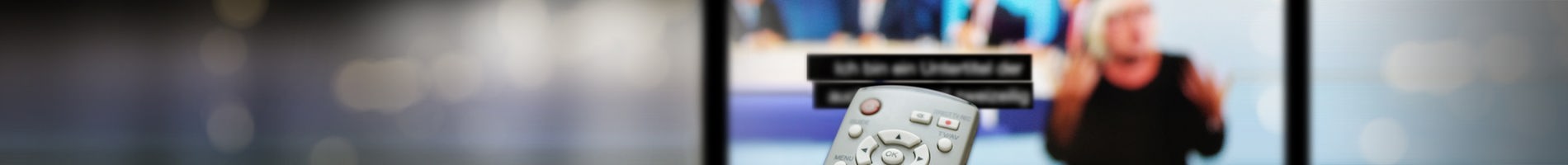 Symbolbild Barrierefreies Angebot - Frau mit Hörgerät bedient ein Tablet