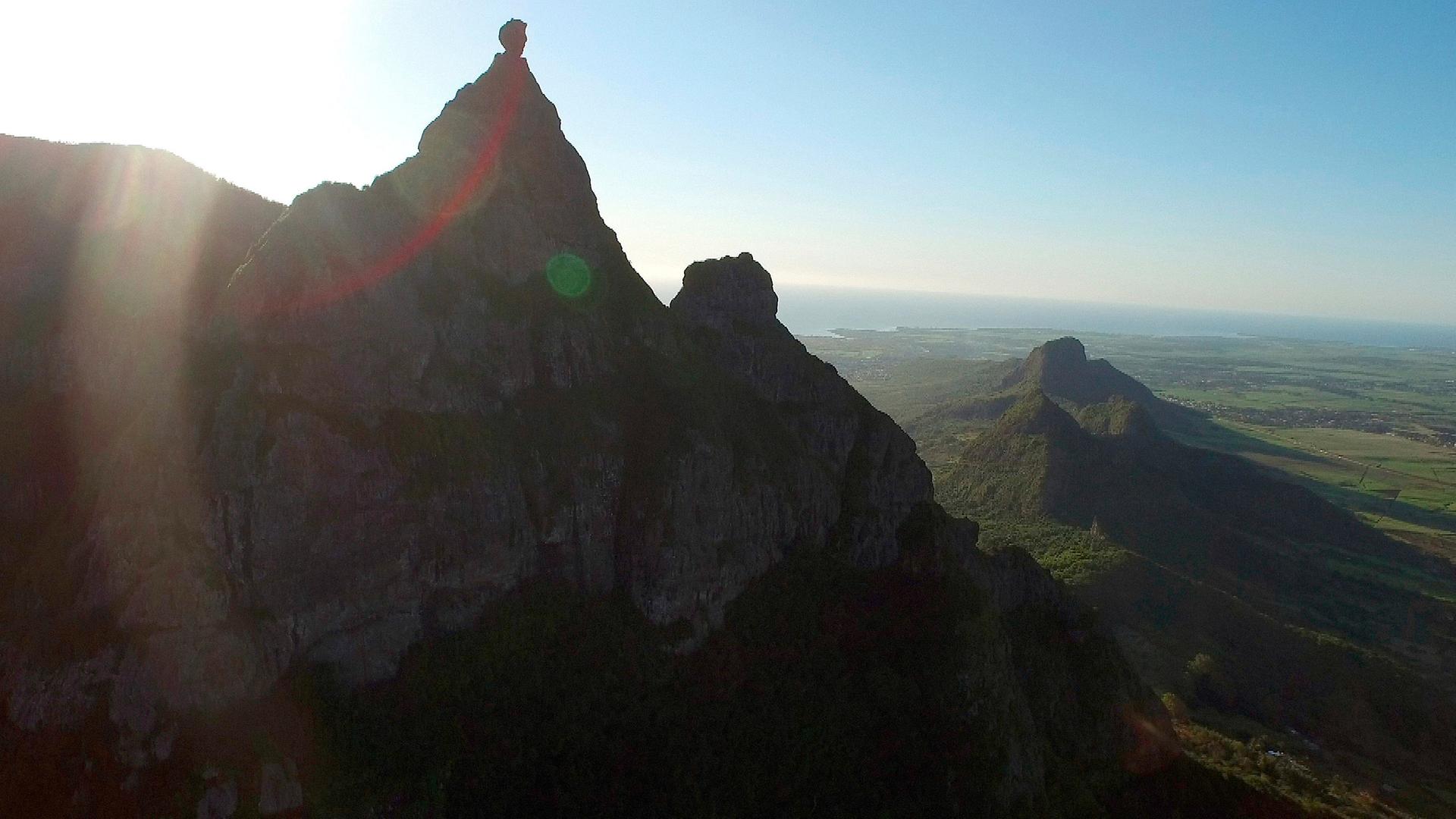 Im Vordergrund eine Bergkette, im Hintegrund das Meer