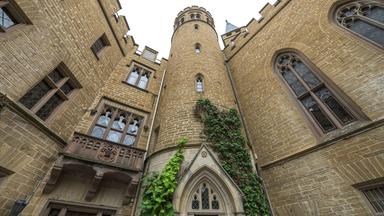 Türme und Wände sind aus Stein gebaut und teils mit Efeu bedeckt.
