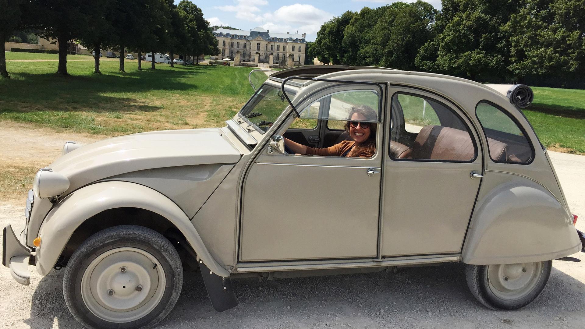 Eine Frau in einem alten Auto.
