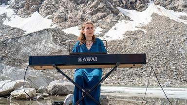 Chiara Schmidt an einem E-Piano bei einem Konzert im Gebirge