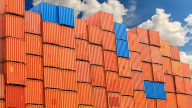 Gestapelte Container vor blauem Himmel