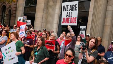 Vor allem Frauen demonstrieren mit Plakaten, auf einem steht "We are all Jane Doe"
