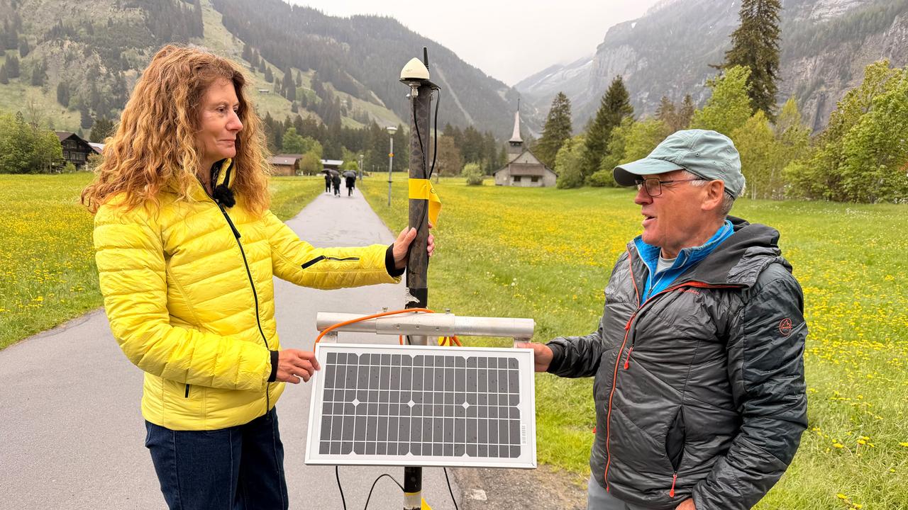 Auf dem Bild stehen eine Frau und ein Mann jeweils links und rechts von einer Art kleinen Solarzelle