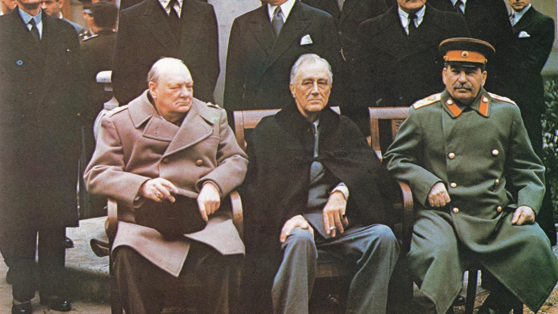 "Countdown zum Kriegsende: Durchbruch im Osten": Winston Churchill, Franklin D. Roosevelt und Josef Stalin sitzen auf Stühlen nebeneinander. Im Hintergrund stehen weitere Herren im Anzug.