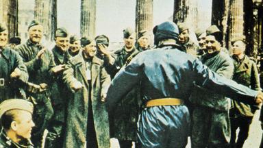 "Countdown zum Kriegsende: Untergang und Befreiung": Ein Soldat der Roten Armee, der nur von hinten zu sehen ist, wird am Brandenburger Tor von anderen Soldaten beklatscht und gefeiert.