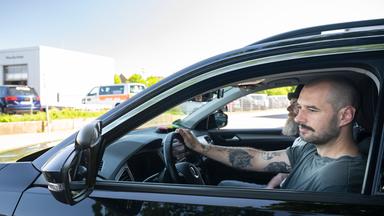 Niklas Schweitzer sitzt am Steuer eines Autos der Fahrschule. Sein Fahrlehrer Axel Steinadler sitzt neben ihm.